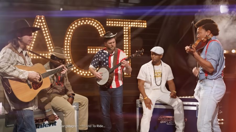 Five brothers performing together on a talent-show stage.