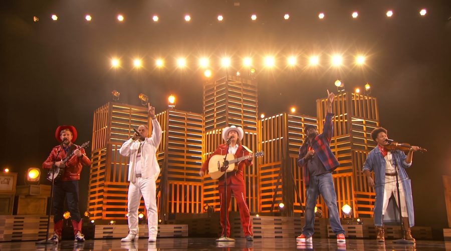Five brothers performing together on a talent-show stage.